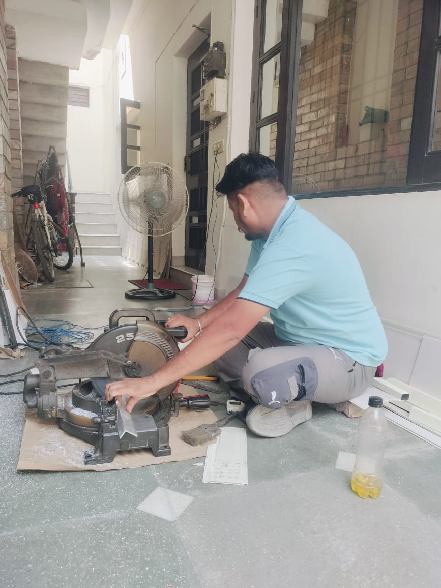 Worker using a mitre saw to cut aluminium track section